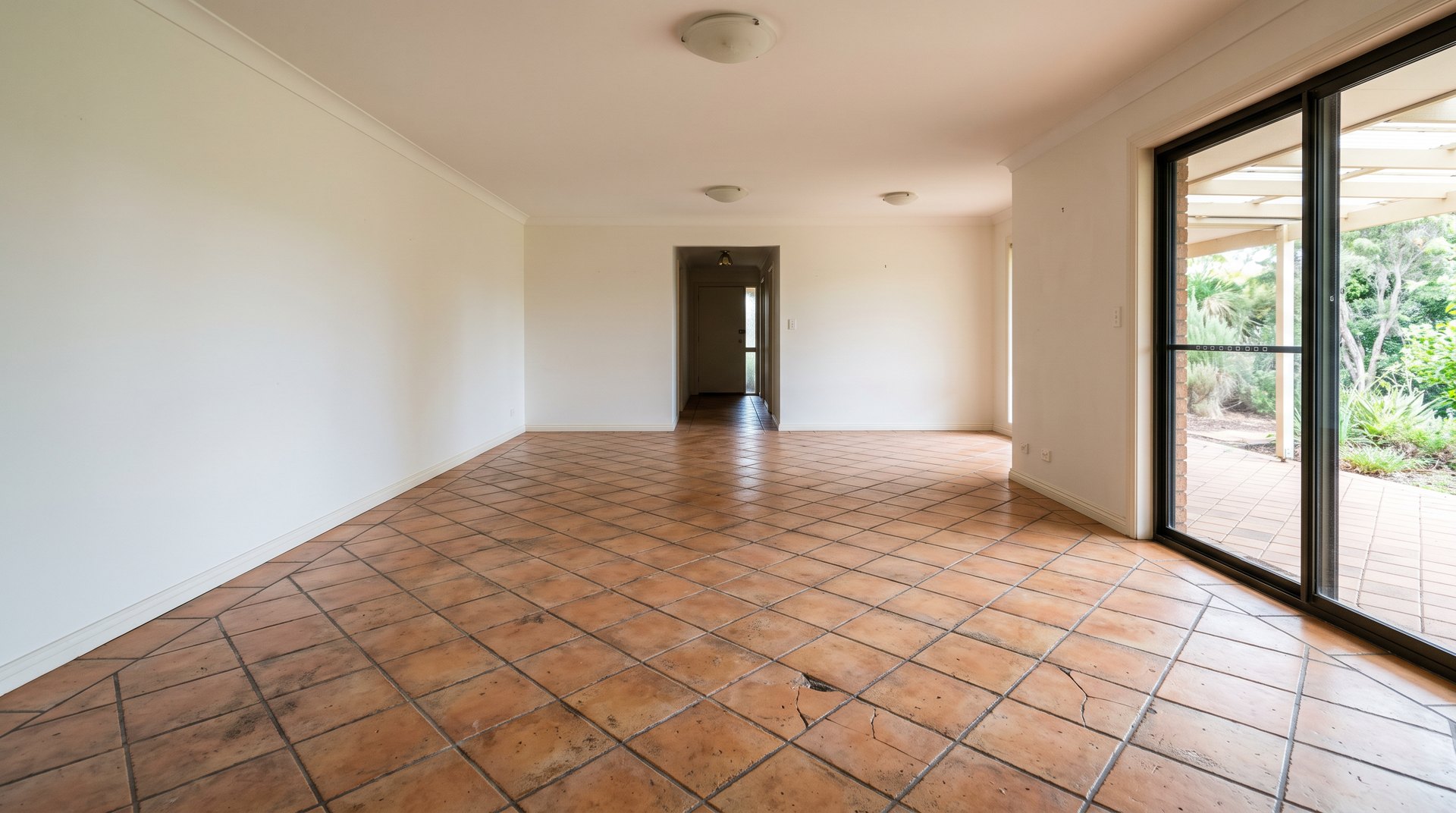 Before: dated terracotta tiled living room floor